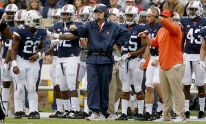 Bronco Mendenhall stands in front of team.